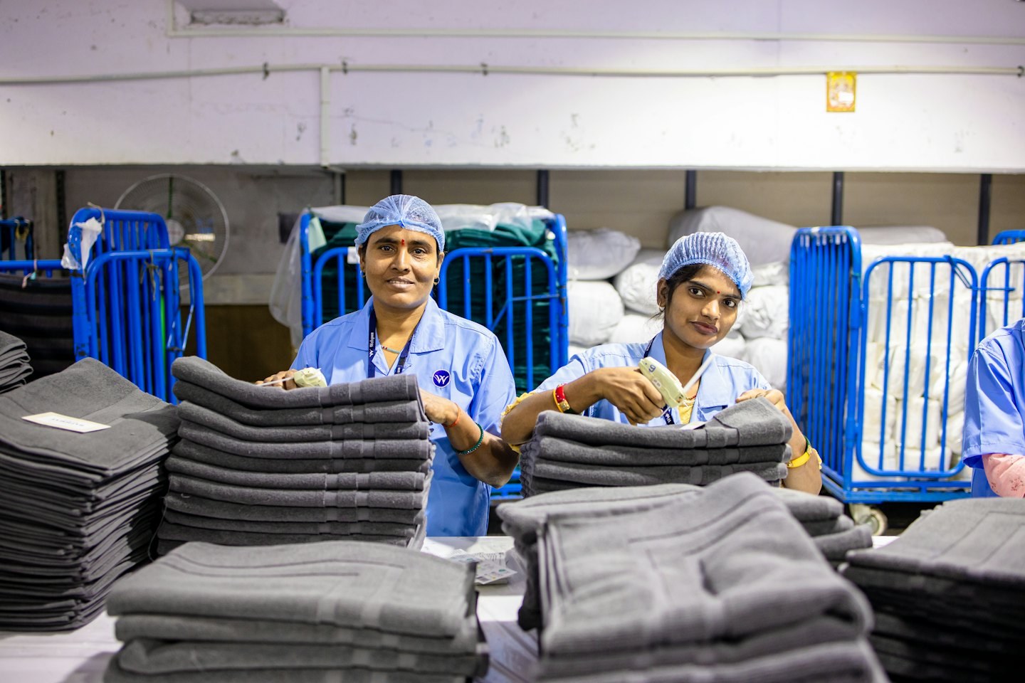 Workers folding linens in a commercial laundry facility