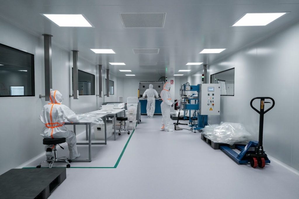 Workers in protective suits in a clean medical facility