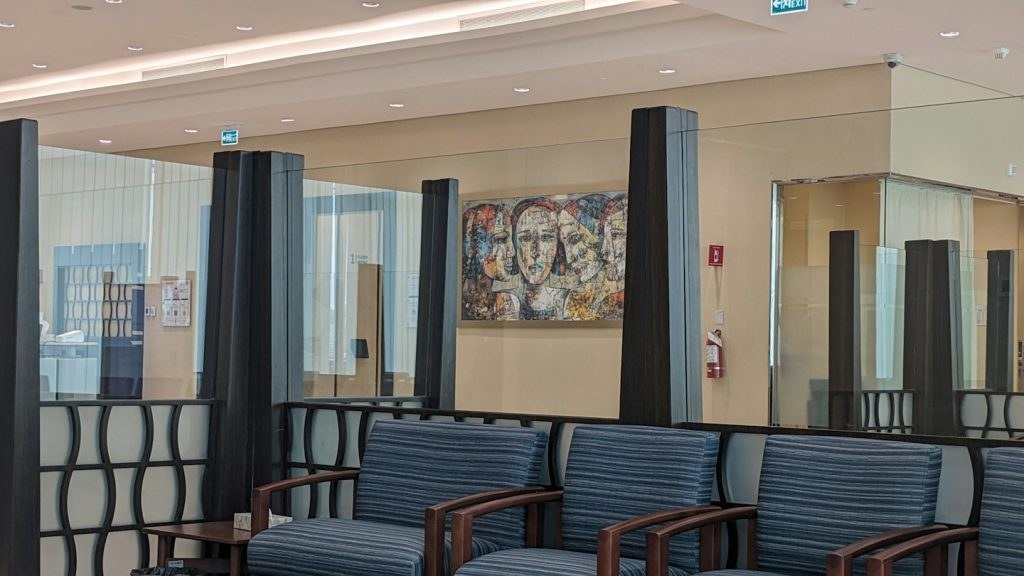 Empty modern waiting room with striped armchairs and abstract art