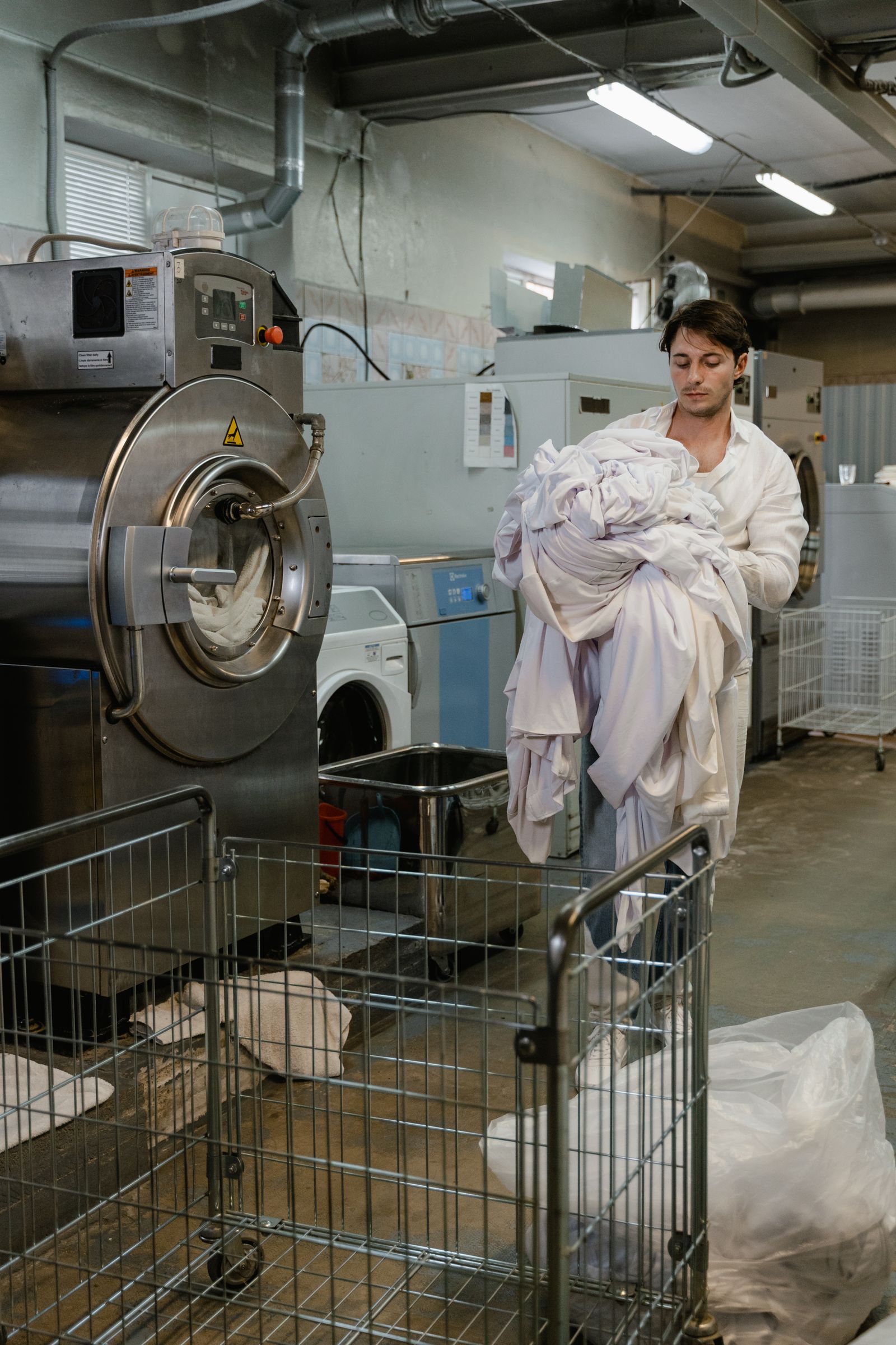 Worker carrying laundry in a commercial laundry facility